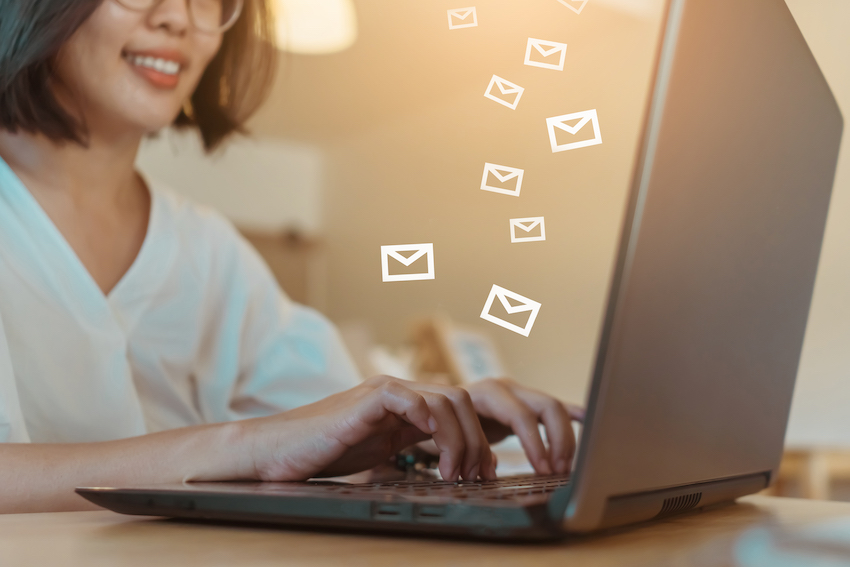 Woman hand using laptop computer to send and recieve email for business on bokeh vintage color tone background.